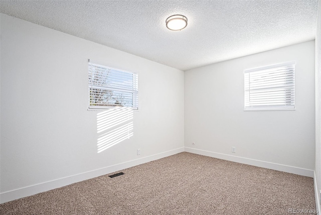 unfurnished room featuring carpet and a textured ceiling