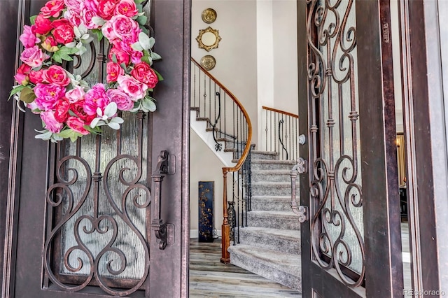 entrance foyer featuring baseboards, wood finished floors, and stairs
