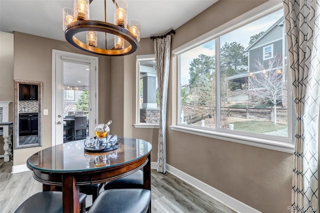 dining room featuring a chandelier, wood finished floors, and baseboards
