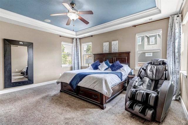 bedroom with ceiling fan, carpet floors, a tray ceiling, baseboards, and ornamental molding