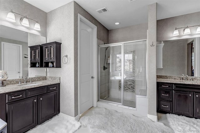 bathroom with visible vents, a sink, and a stall shower