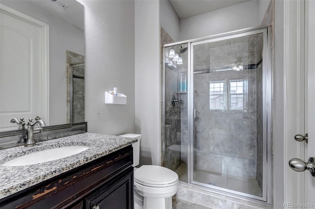 full bathroom with toilet, vanity, and a stall shower