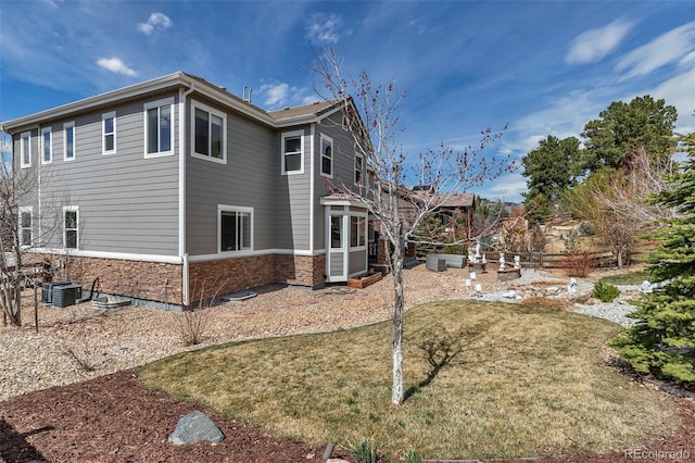 view of side of property featuring a patio area, a lawn, and central air condition unit