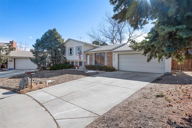 tri-level home with an attached garage, concrete driveway, and brick siding