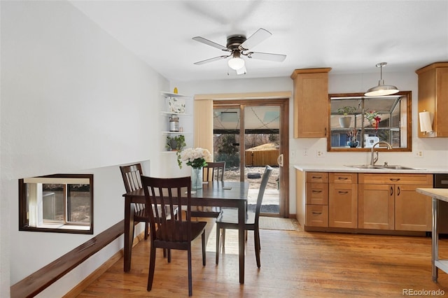 dining area with a ceiling fan, baseboards, and light wood finished floors