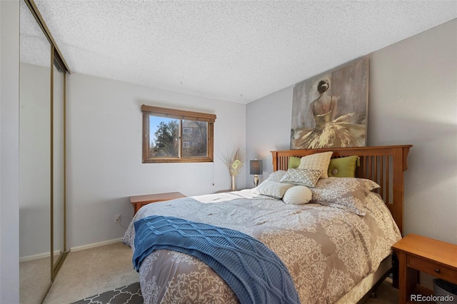 bedroom featuring a textured ceiling, a closet, carpet, and baseboards