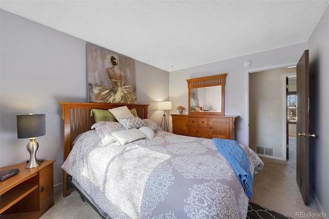 bedroom with visible vents, light carpet, baseboards, and a textured ceiling