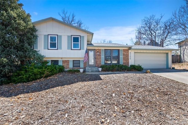 tri-level home featuring board and batten siding, concrete driveway, brick siding, and an attached garage