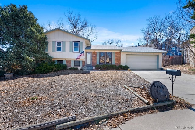 tri-level home featuring a garage, driveway, and brick siding