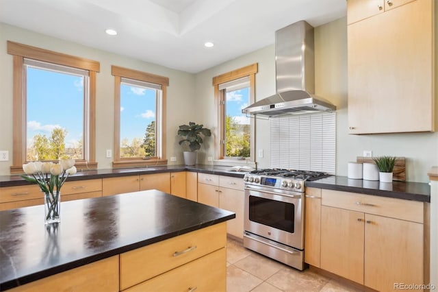 4305 Easley Rd, Golden, CO 80403 - kitchen featuring stainless steel range with gas stovetop, dark countertops, light brown cabinetry, and wall chimney range hood