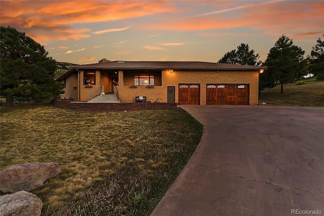 view of front of property featuring a garage and a lawn