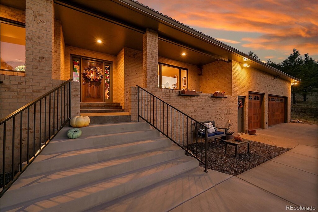 doorway to property featuring concrete driveway and brick siding
