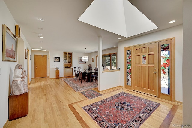 foyer entrance with recessed lighting, baseboards, and light wood finished floors