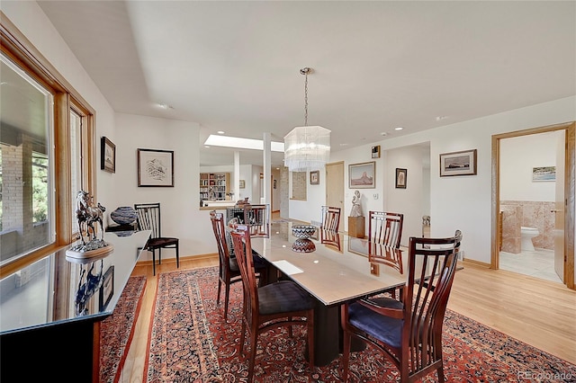 dining room featuring light wood-style floors and an inviting chandelier