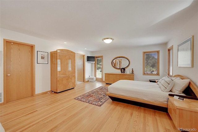 bedroom featuring multiple windows, light wood-style flooring, and baseboards