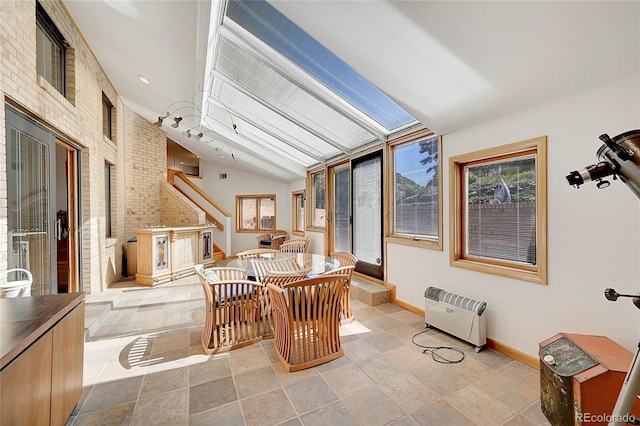 sunroom with lofted ceiling and heating unit