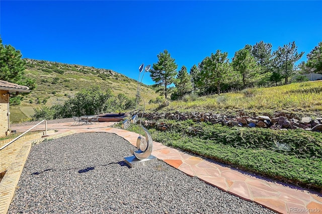 view of yard featuring a mountain view and a patio