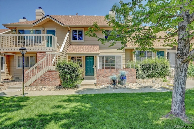2181 S Troy Way Unit 103, Aurora, CO 80014 - townhome / multi-family property featuring stairs, brick siding, a front lawn, and a chimney