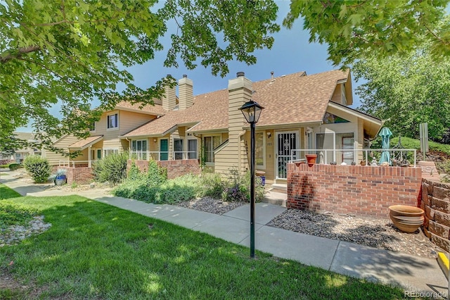 2181 S Troy Way Unit 103, Aurora, CO 80014 - view of front facade featuring a front lawn, a shingled roof, and a chimney