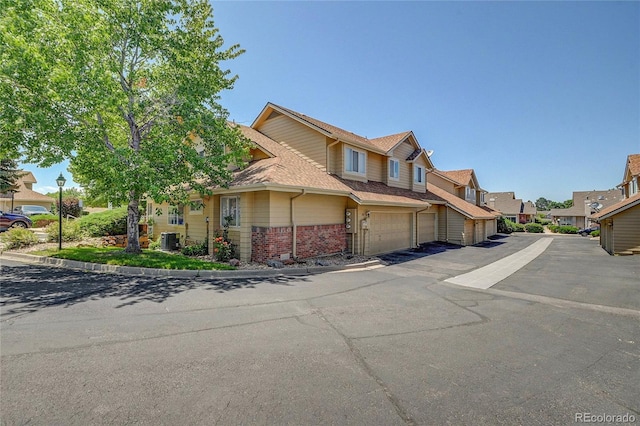 2181 S Troy Way Unit 103, Aurora, CO 80014 - view of front of property with brick siding, a residential view, a garage, and a shingled roof