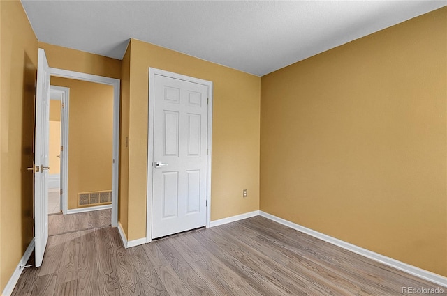 2181 S Troy Way Unit 103, Aurora, CO 80014 - unfurnished bedroom featuring wood finished floors and baseboards