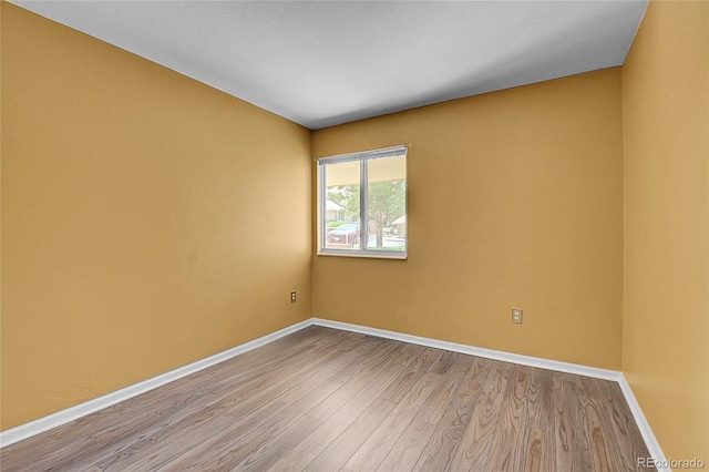 2181 S Troy Way Unit 103, Aurora, CO 80014 - spare room featuring wood finished floors and baseboards