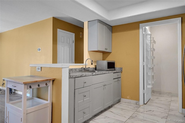 2181 S Troy Way Unit 103, Aurora, CO 80014 - laundry area with light marble finish flooring and a sink