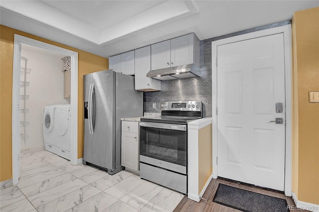 2181 S Troy Way Unit 103, Aurora, CO 80014 - kitchen with stainless steel appliances, under cabinet range hood, washing machine and clothes dryer, light countertops, and light marble finish flooring