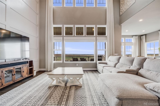 8750 Red Primrose St, Franktown, CO 80116 - living area with baseboards, dark wood-type flooring, recessed lighting, and a towering ceiling