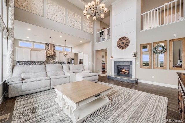 8750 Red Primrose St, Franktown, CO 80116 - living room with an inviting chandelier, baseboards, a high ceiling, and dark wood-type flooring
