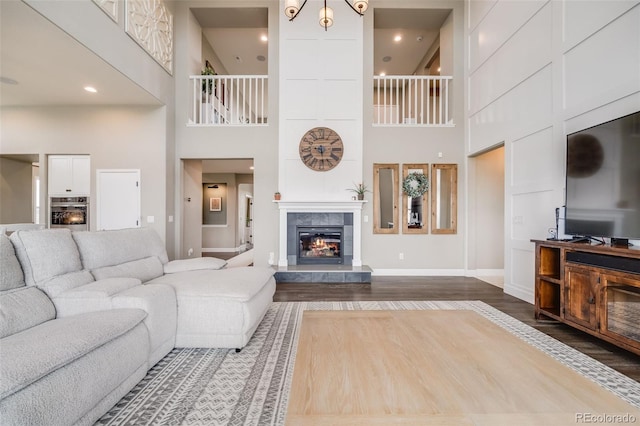 8750 Red Primrose St, Franktown, CO 80116 - living area with a high ceiling, dark wood finished floors, a tiled fireplace, and baseboards