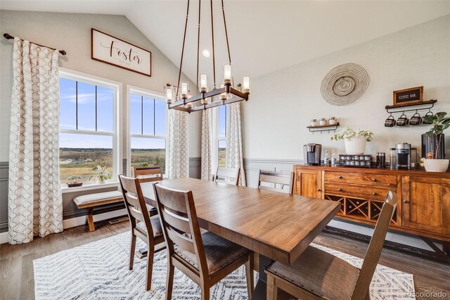8750 Red Primrose St, Franktown, CO 80116 - dining room featuring vaulted ceiling, wood finished floors, and a notable chandelier