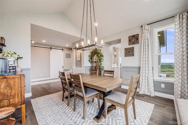 8750 Red Primrose St, Franktown, CO 80116 - dining room with dark wood-style floors, a barn door, lofted ceiling, and a wainscoted wall