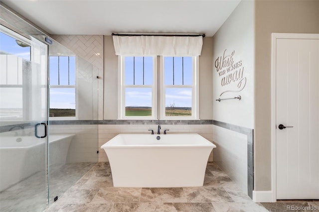 8750 Red Primrose St, Franktown, CO 80116 - full bathroom with a freestanding tub, tile walls, and a shower stall