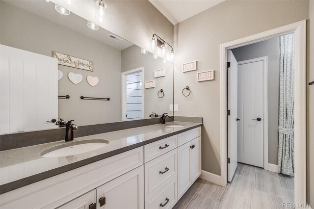8750 Red Primrose St, Franktown, CO 80116 - bathroom featuring a sink, baseboards, and double vanity