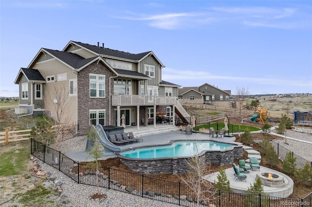 8750 Red Primrose St, Franktown, CO 80116 - back of property with stairs, board and batten siding, a deck, a patio area, and a fire pit