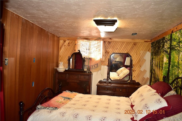 bedroom featuring a textured ceiling, multiple windows, and wooden walls