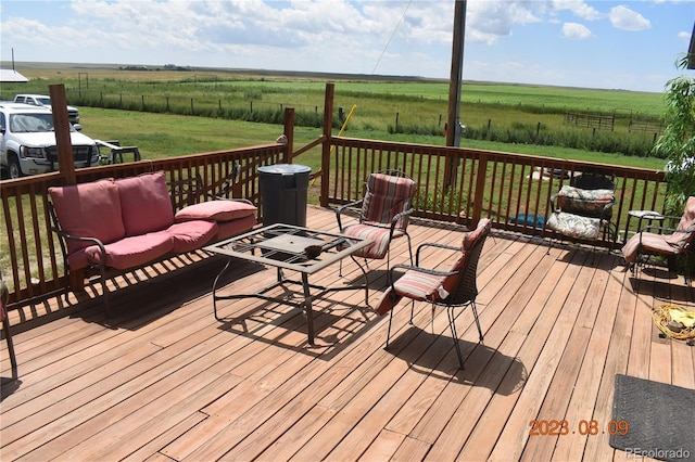 deck with a yard, an outdoor hangout area, and a rural view