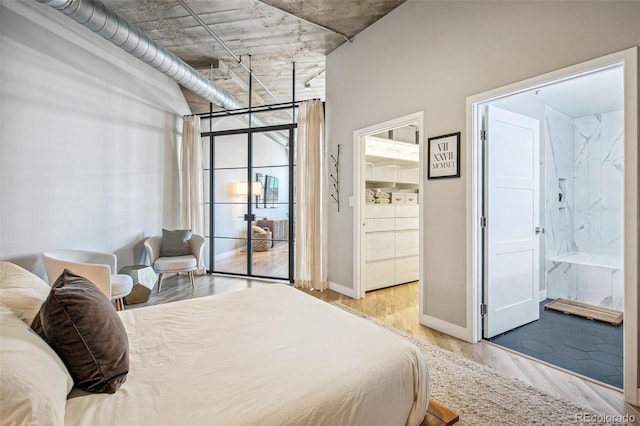 bedroom featuring connected bathroom and light hardwood / wood-style floors