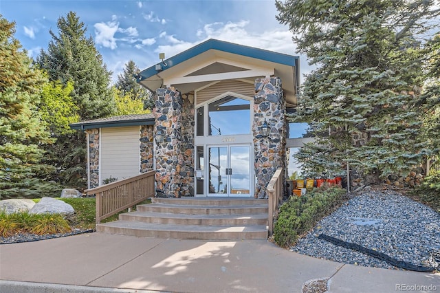 entrance to property featuring stone siding
