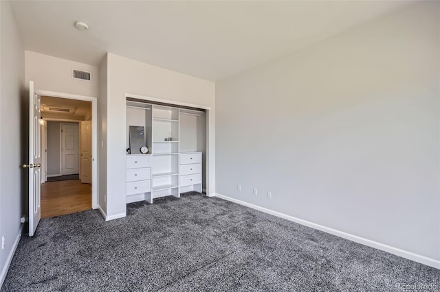 unfurnished bedroom featuring dark colored carpet, baseboards, and a closet