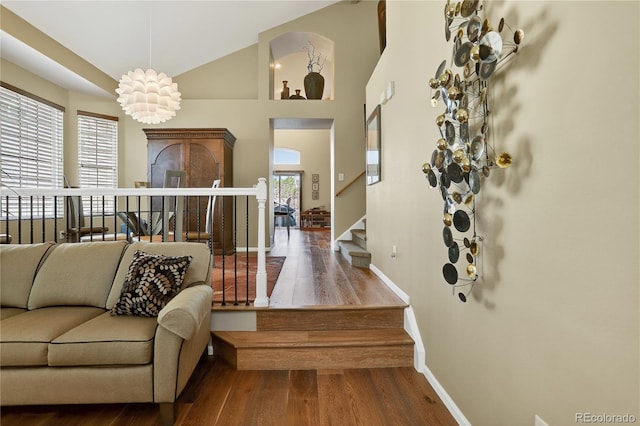 18153 E Amherst Dr, Aurora, CO 80013 - living area featuring wood finished floors, stairs, and high vaulted ceiling