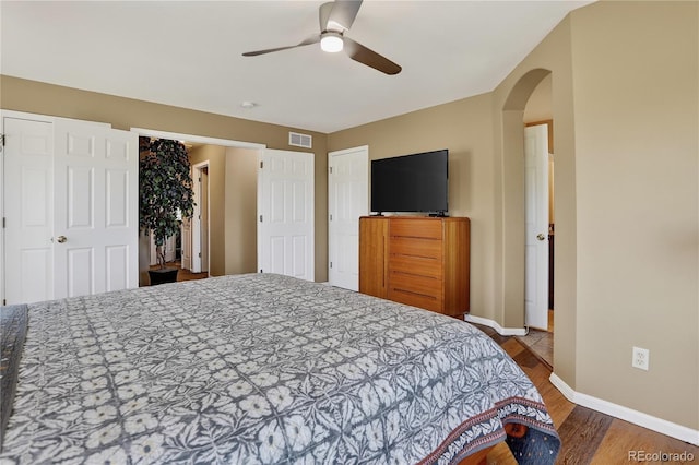 18153 E Amherst Dr, Aurora, CO 80013 - bedroom featuring wood finished floors, arched walkways, and ceiling fan