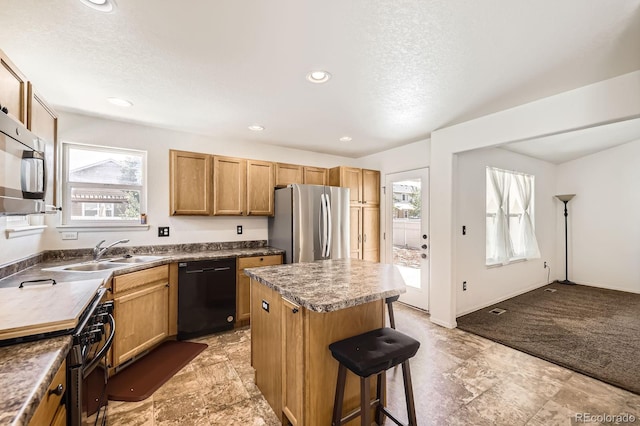 5770 Waverley Ave, Firestone, CO 80504 - kitchen featuring appliances with stainless steel finishes, a kitchen bar, a kitchen island, a textured ceiling, and dark countertops
