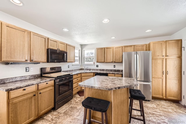 5770 Waverley Ave, Firestone, CO 80504 - kitchen featuring black appliances, a breakfast bar, recessed lighting, a center island, and dark countertops