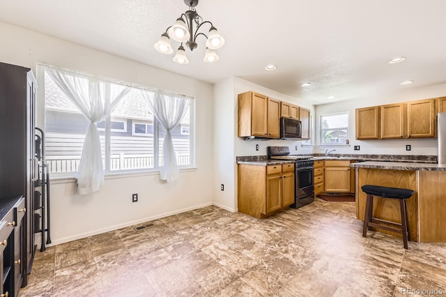 5770 Waverley Ave, Firestone, CO 80504 - kitchen with gas stove, black microwave, a chandelier, a breakfast bar area, and dark countertops