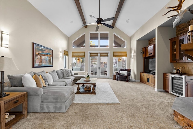 carpeted living room with wine cooler, bar, ceiling fan, high vaulted ceiling, and beamed ceiling