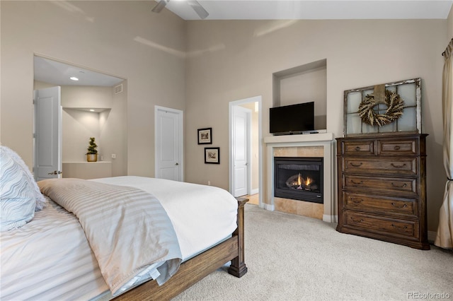 carpeted bedroom featuring ceiling fan, high vaulted ceiling, and a tiled fireplace