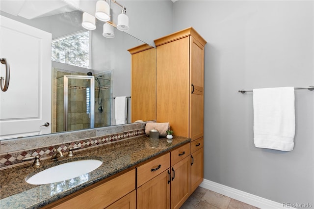 bathroom featuring tile patterned floors, vanity, an enclosed shower, and a notable chandelier