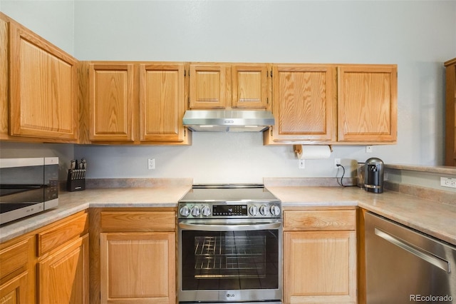 kitchen with under cabinet range hood, appliances with stainless steel finishes, and light countertops